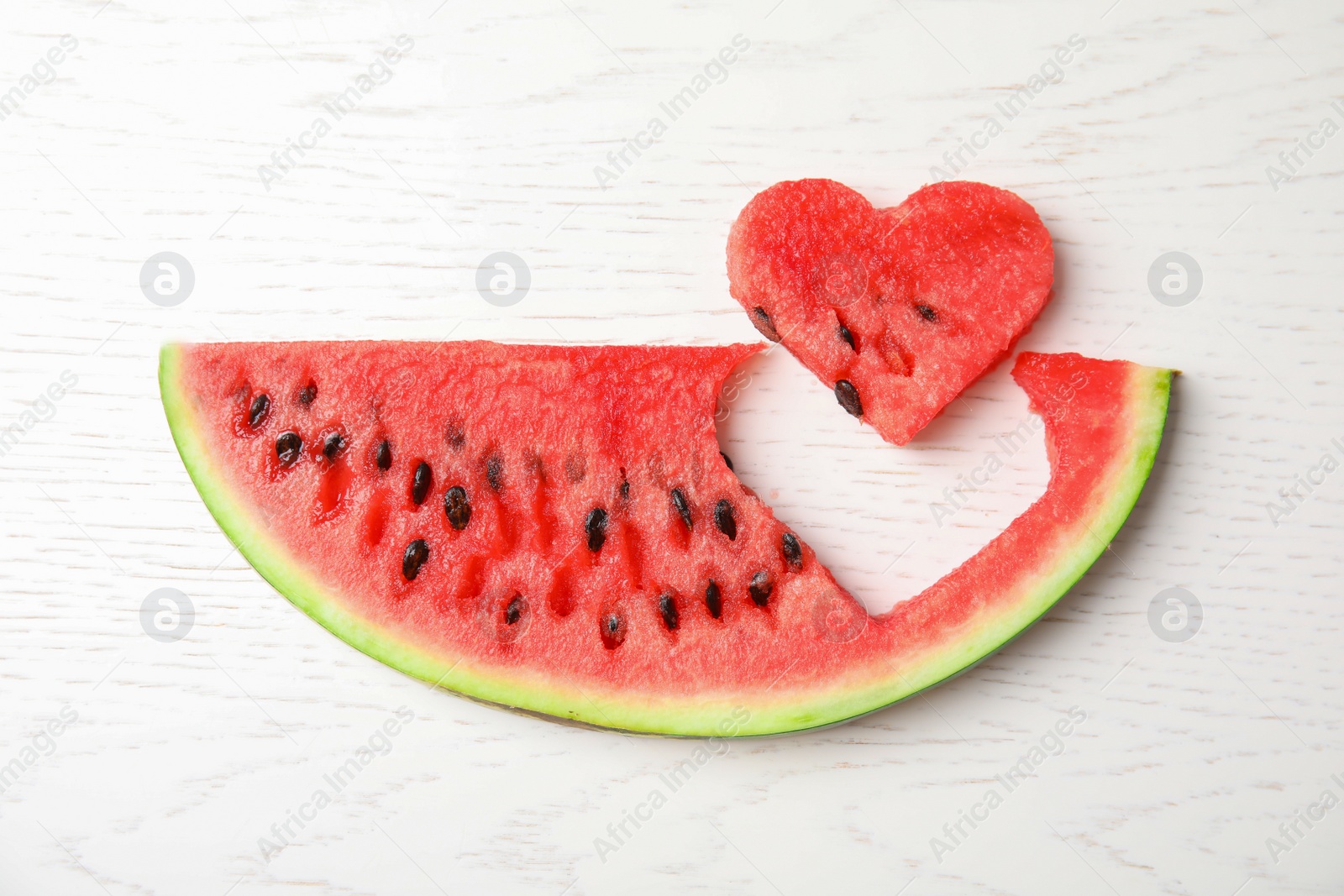 Photo of Slice of watermelon on white wooden background, top view