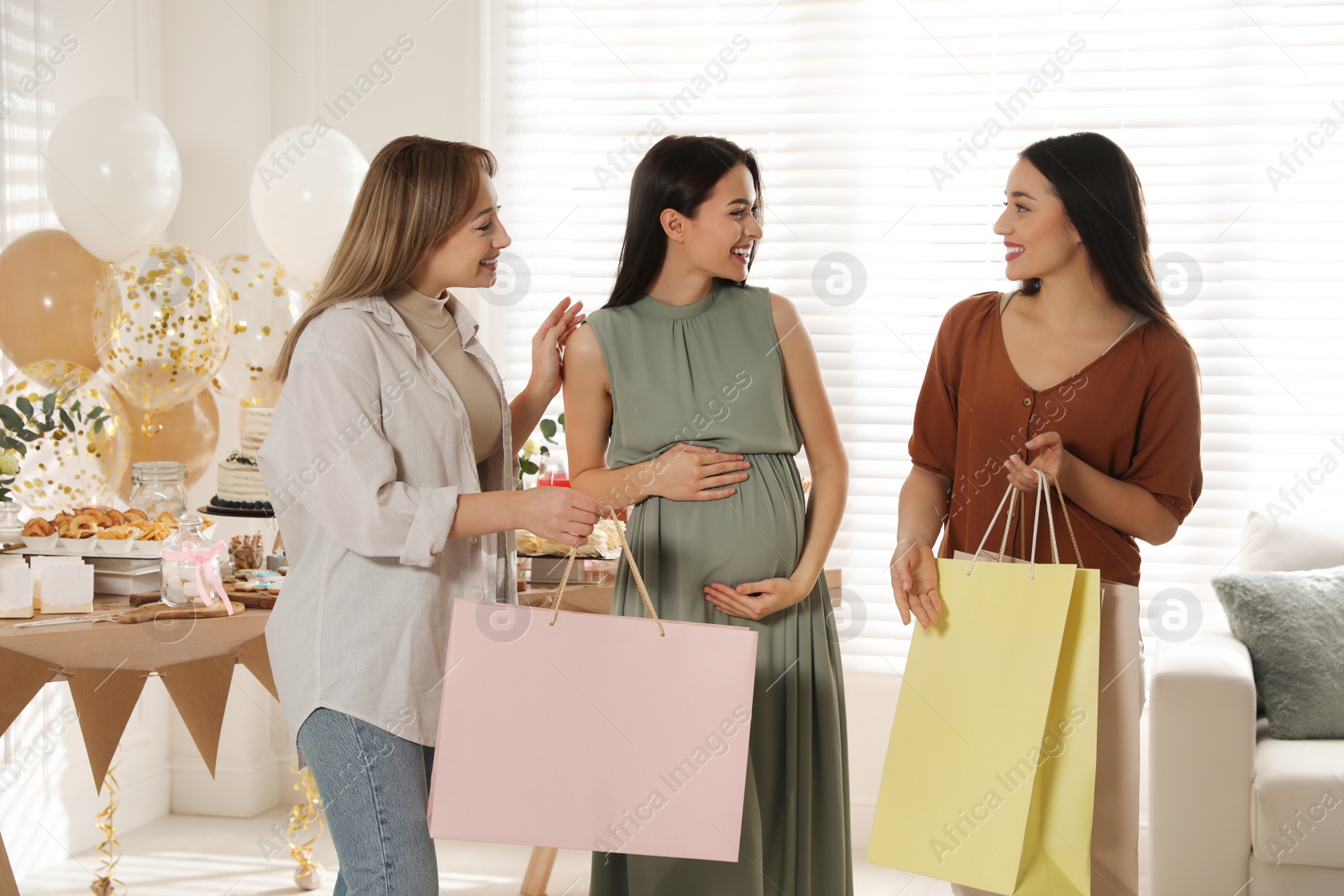 Photo of Happy pregnant woman spending time with friends at baby shower party