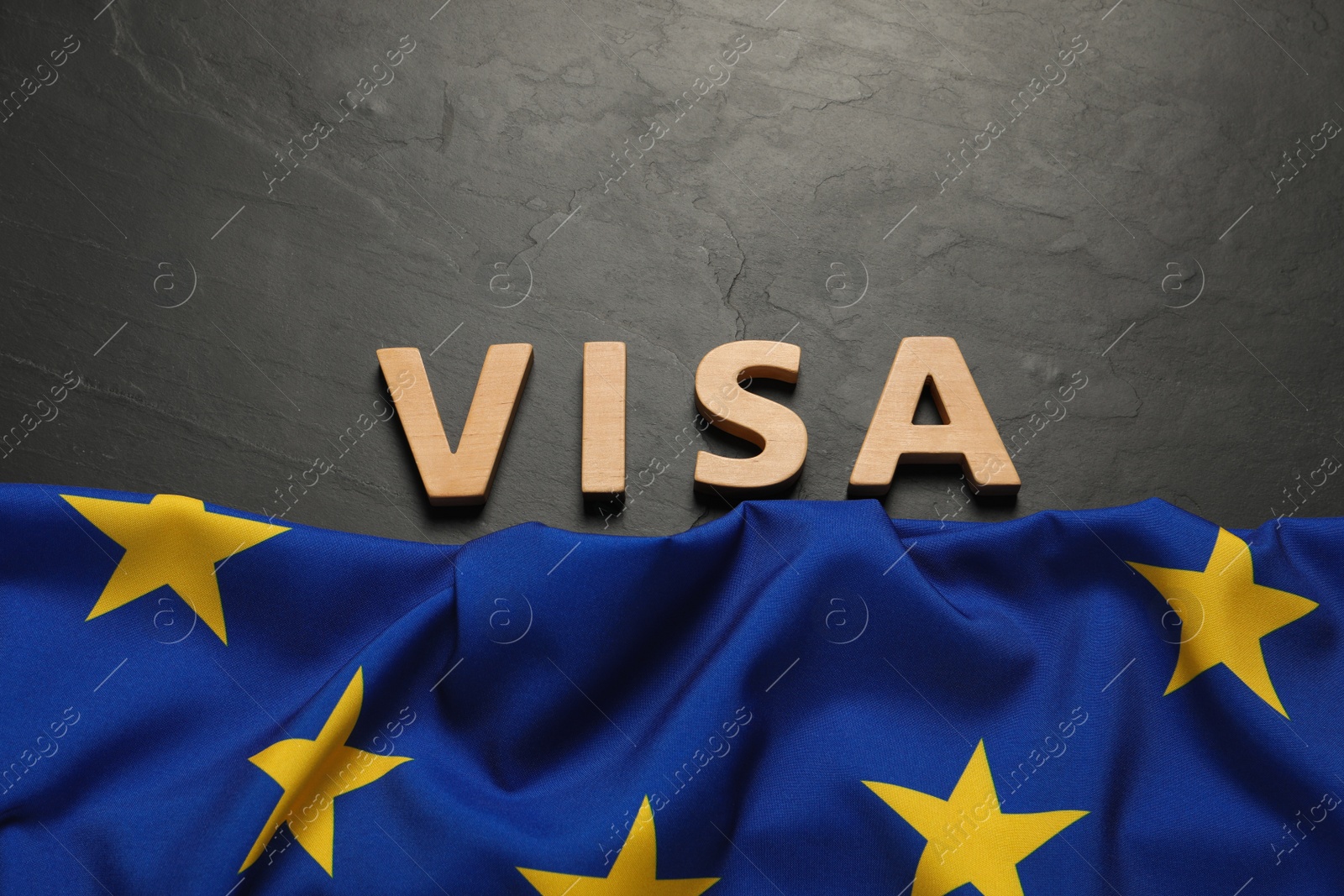 Photo of Word Visa made of wooden letters and European Union flag on black table, flat lay