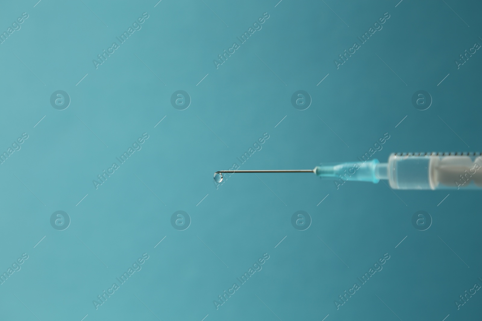 Photo of Medical syringe on light blue background, closeup. Space for text