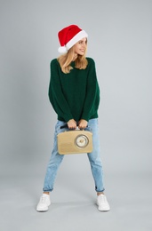 Photo of Happy woman with vintage radio on grey background. Christmas music