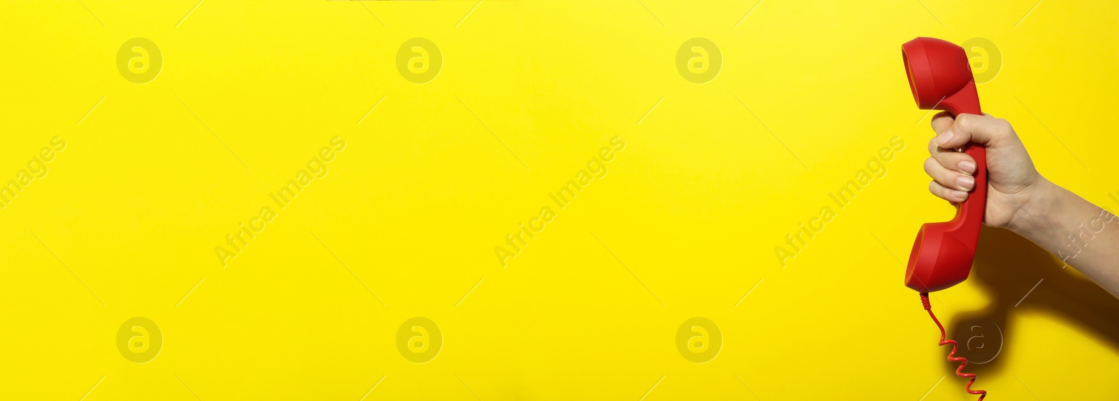 Image of Hotline service. Woman with telephone receiver and space for text on yellow background, banner design