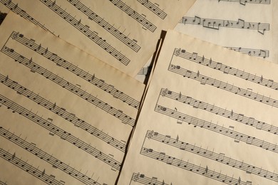 Many old note sheets as background, top view