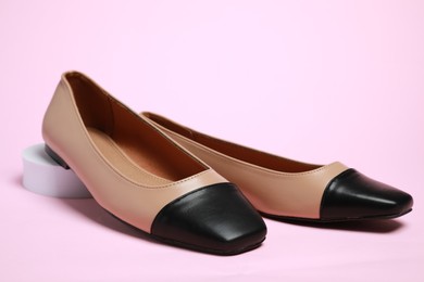 Photo of Pair of new stylish square toe ballet flats on pale pink background