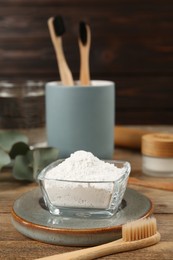 Photo of Tooth powder and brush on wooden table
