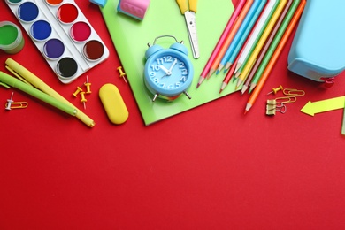 Photo of Bright school stationery on red background, flat lay. Space for text