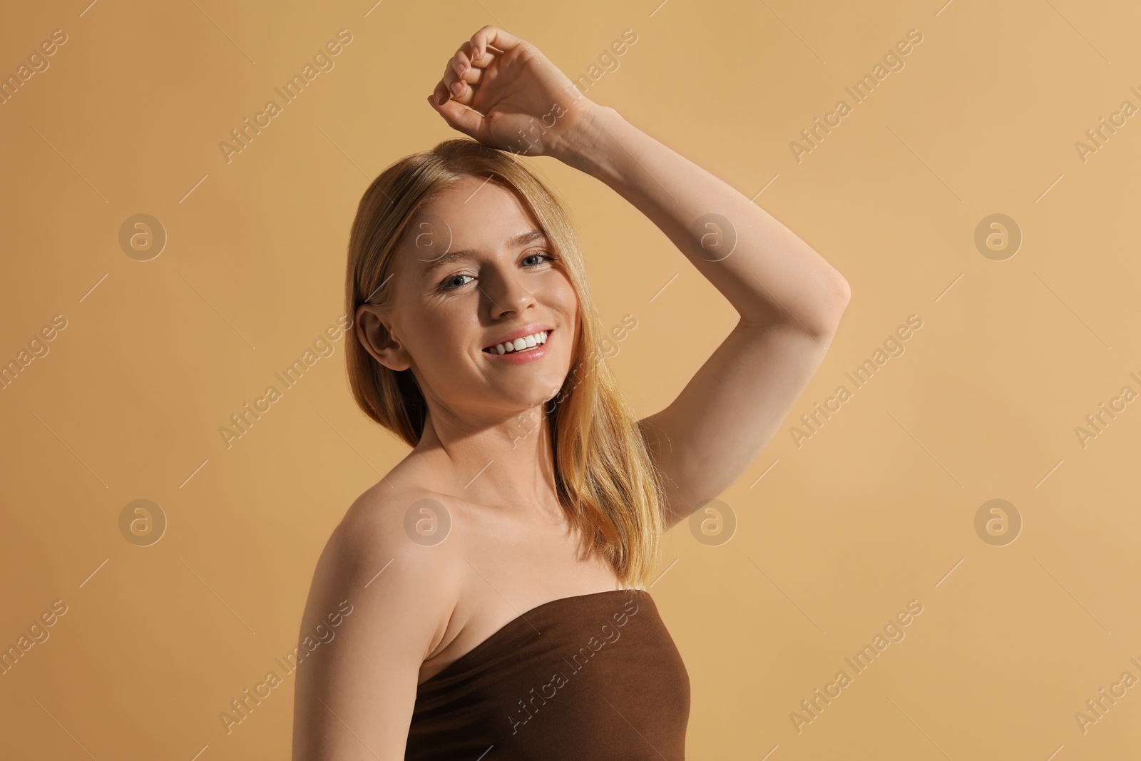 Photo of Beautiful young woman posing on beige background