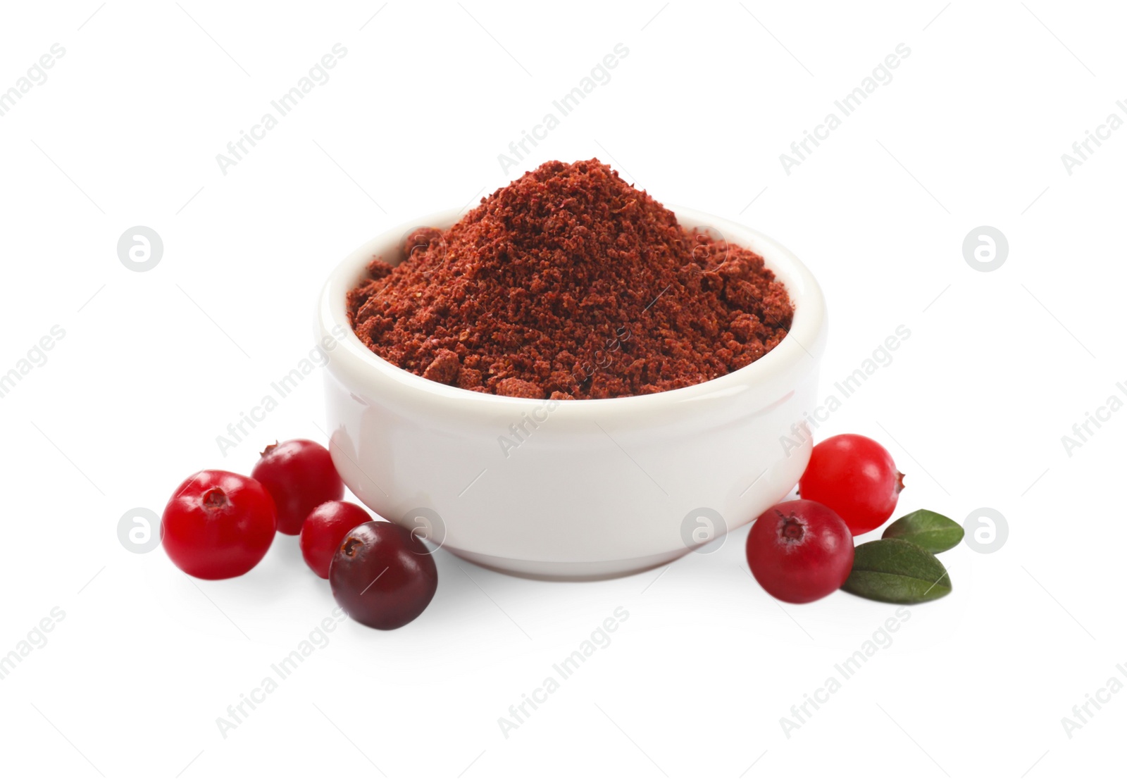 Photo of Dried cranberry powder in bowl, fresh berries and green leaves isolated on white