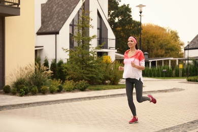 Beautiful sporty woman running on street. Healthy lifestyle