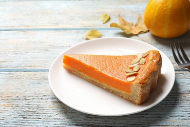 Plate with piece of fresh delicious homemade pumpkin pie on wooden table