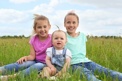 Photo of Cute happy girls on green grass in field
