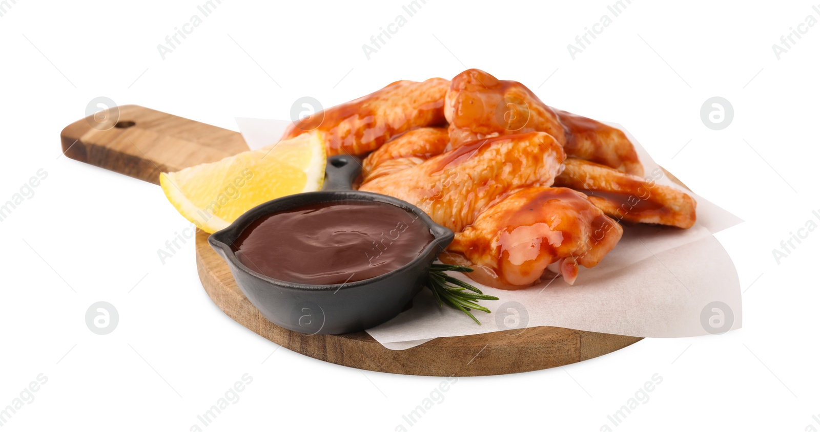 Photo of Board with marinade, raw chicken wings, rosemary and lemon isolated on white