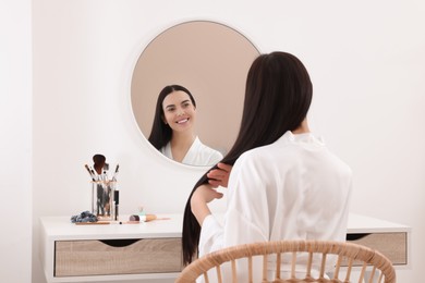 Photo of Beautiful young woman at dressing table indoors