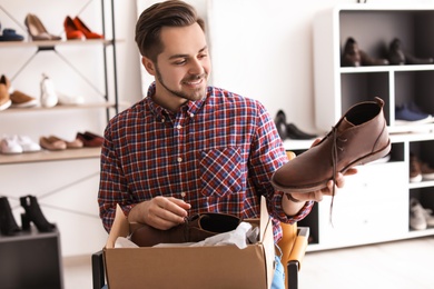 Photo of Young man choosing shoes in store