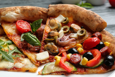 Photo of Slices of different delicious pizzas on plate, closeup