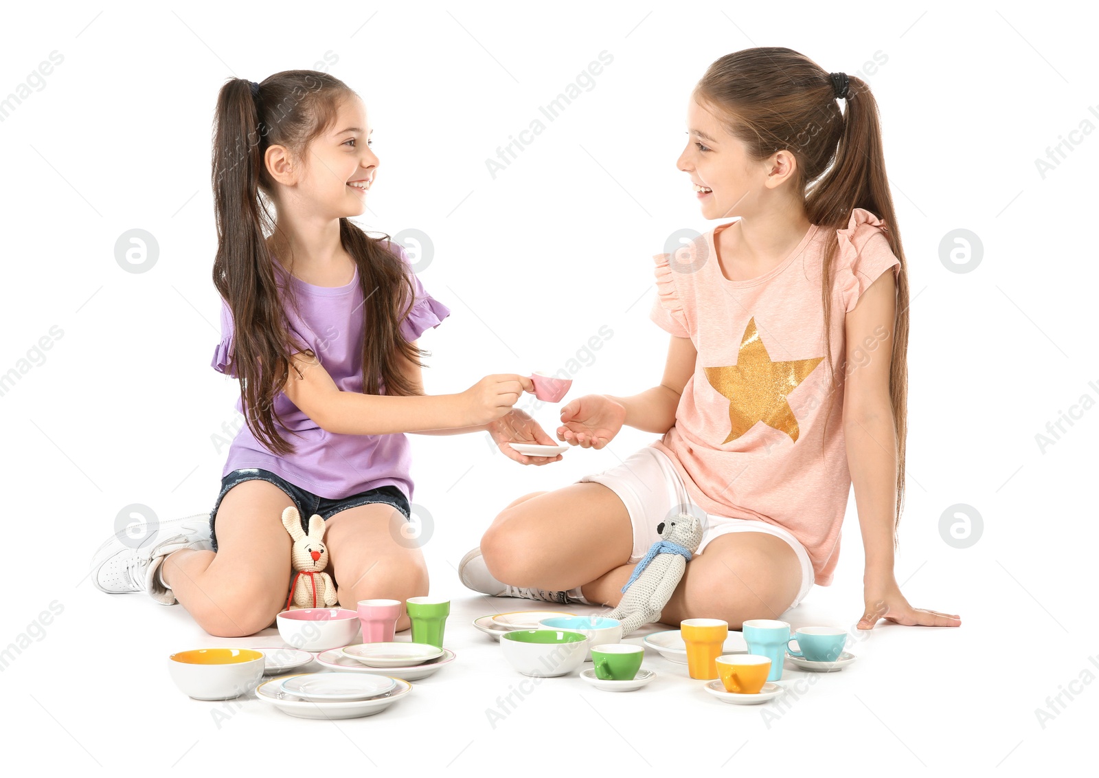 Photo of Little children playing tea party with toys on white background. Indoor entertainment