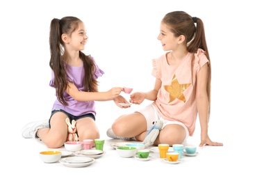 Photo of Little children playing tea party with toys on white background. Indoor entertainment