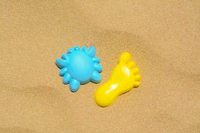 Photo of Colorful plastic molds on sand, flat lay. Beach toys