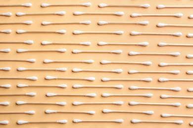Photo of Flat lay composition with cotton swabs on color background