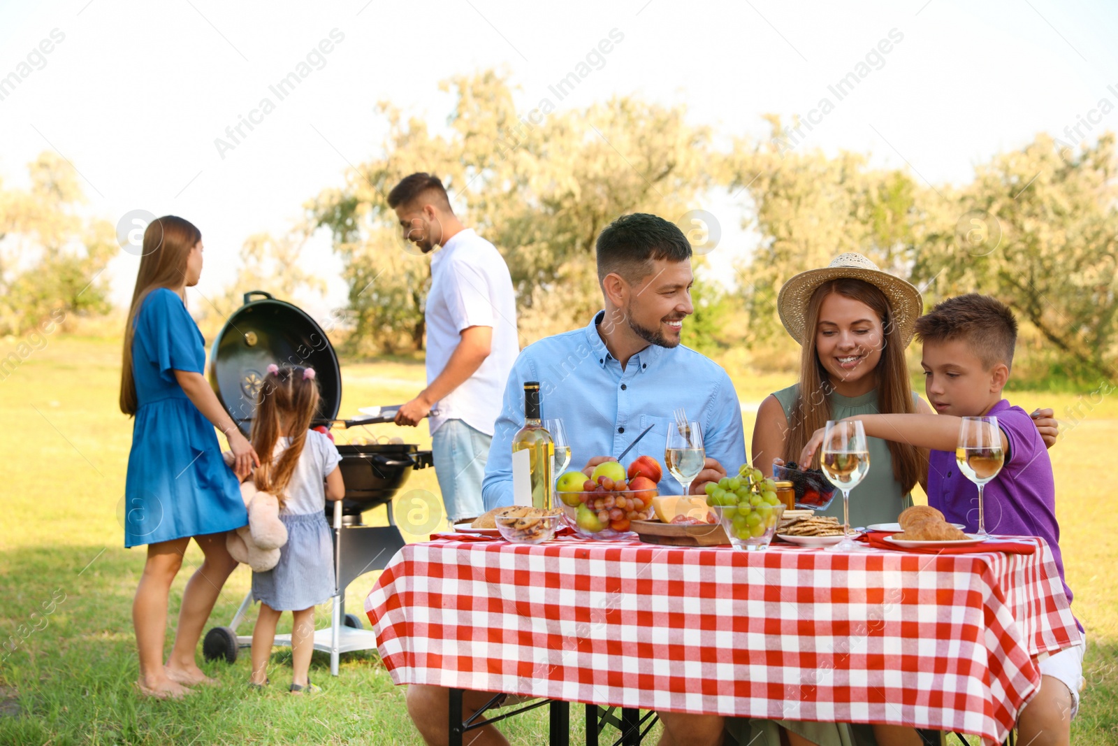 Photo of Happy families with little children having picnic in park