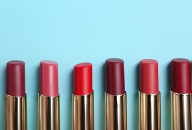 Photo of Flat lay composition with different stylish lipsticks on color background, space for text
