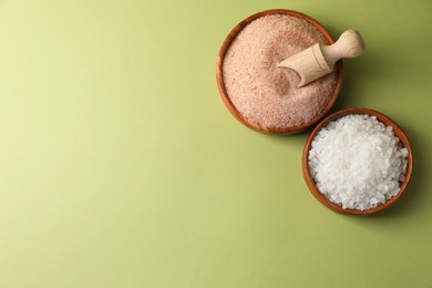 Photo of Different natural salt on green background, flat lay. Space for text