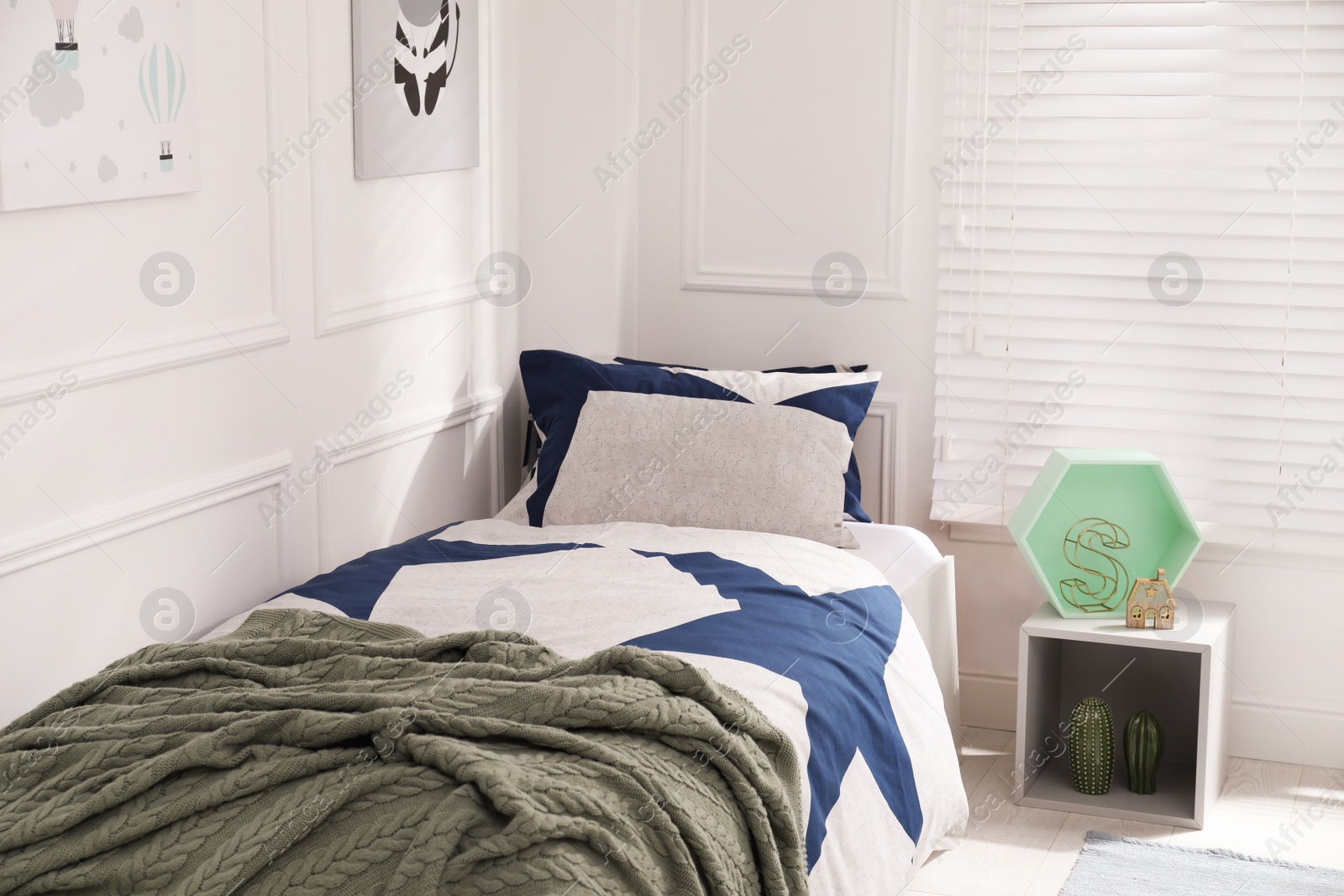 Photo of Bed with stylish linens in children's room