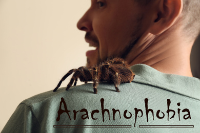Image of Scared man with tarantula on beige background, closeup. Arachnophobia (fear of spiders)