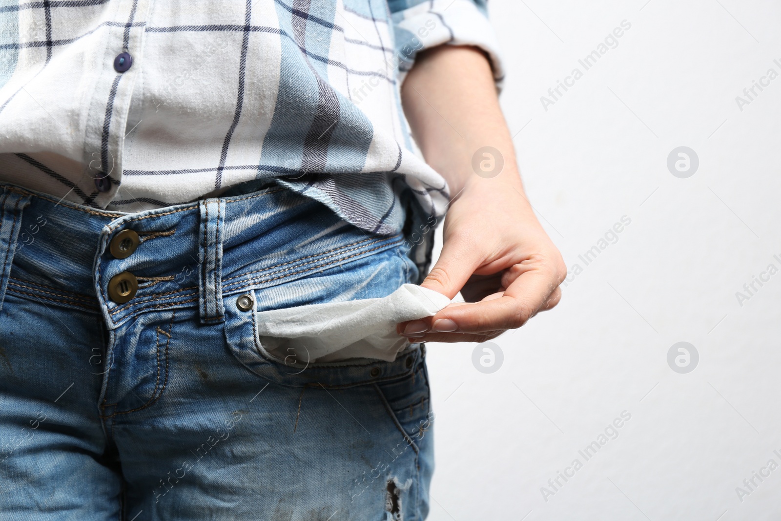 Woman showing empty pocket on light background, closeup Photo of Woman showing empty pocket on light background, closeup