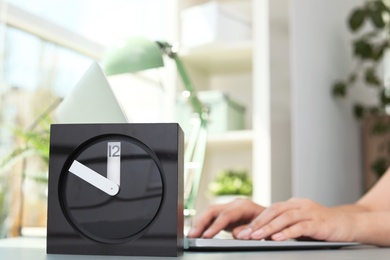 Stylish analog clock on table in office. Time to work