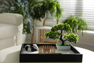 Photo of Beautiful miniature zen garden with incense sticks on table indoors