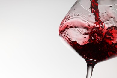 Photo of Tasty red wine in glass on white background, closeup. Space for text