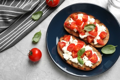 Photo of Flat lay composition with tasty bruschettas on grey table. Space for text