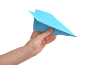 Photo of Woman holding light blue paper plane on white background, closeup