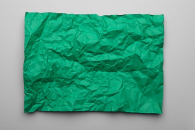 Photo of Color sheet of crumpled paper on grey background, top view