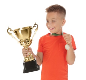 Photo of Happy boy with golden winning cup and medal isolated on white