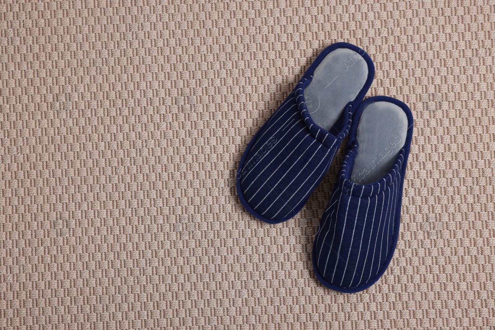 Photo of Pair of stylish slippers on carpet, top view. Space for text