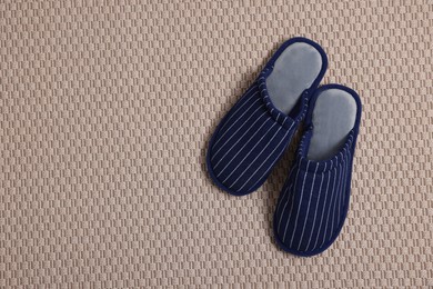 Photo of Pair of stylish slippers on carpet, top view. Space for text