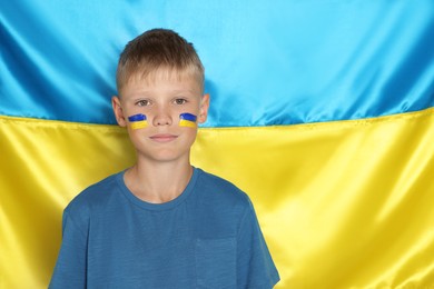 Photo of Little boy near Ukrainian flag. No war concept