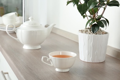 Photo of Cup of hot aromatic tea on table
