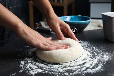 Photo of Woman kneading dough for pastry on table