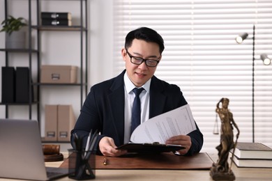 Photo of Notary working at wooden table in office