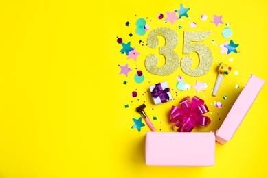 Photo of Flat lay composition with decor and numbers on yellow background, space for text. 35th birthday party