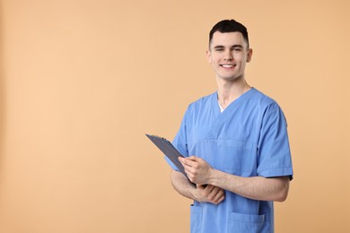 Photo of Portrait of smiling medical assistant with clipboard on beige background. Space for text