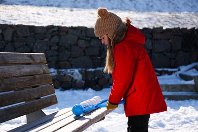 Photo of Cute little girl playing with snowball maker outdoors