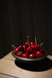 Photo of Sweet red cherries in bowl on wooden table