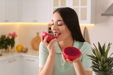 Photo of Young woman with fresh pitahaya in kitchen, space for text. Exotic fruit
