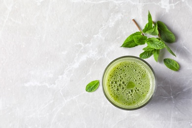 Photo of Glass with delicious detox juice and mint on light background, top view
