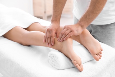 Photo of Young woman receiving massage in salon, closeup