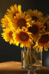 Photo of Bouquet of beautiful sunflowers on table indoors, closeup